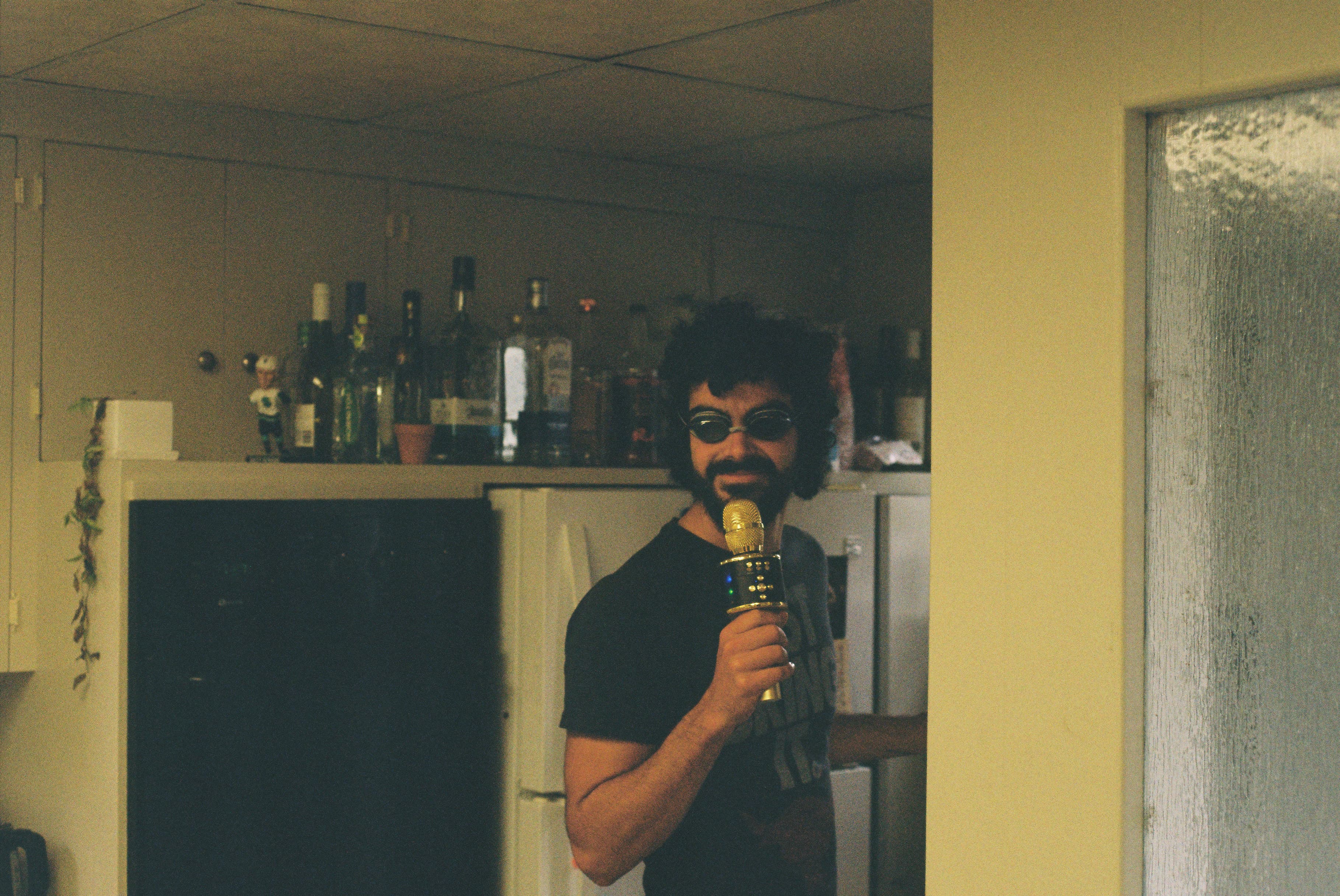 Wearing goggles and holding a karaoke mic